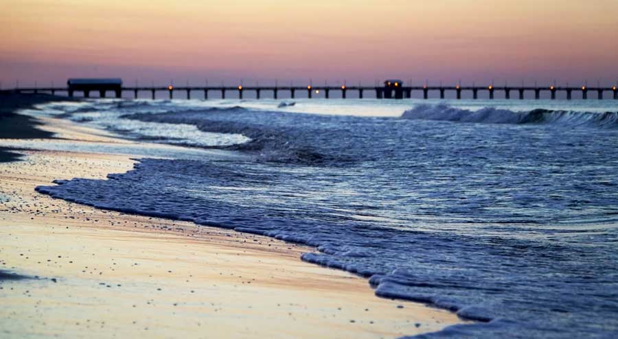 Colorful sky over a pier in Gulf Coast during sunrise