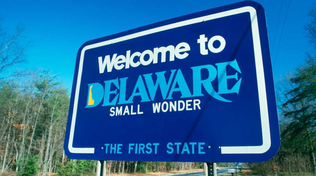 A welcome sign under the clear blue sky in Delaware, reading "Welcome to Delaware, The First State", one of the things Delaware is known for