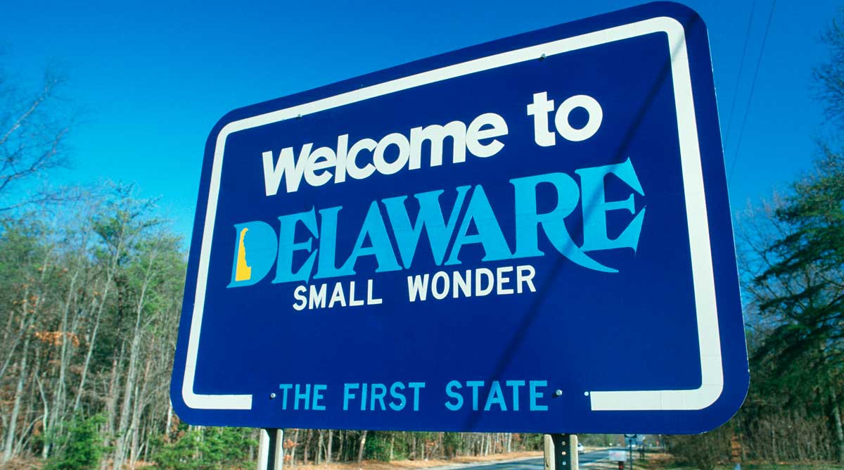 A welcome sign under the clear blue sky in Delaware, reading "Welcome to Delaware, The First State", one of the things Delaware is known for