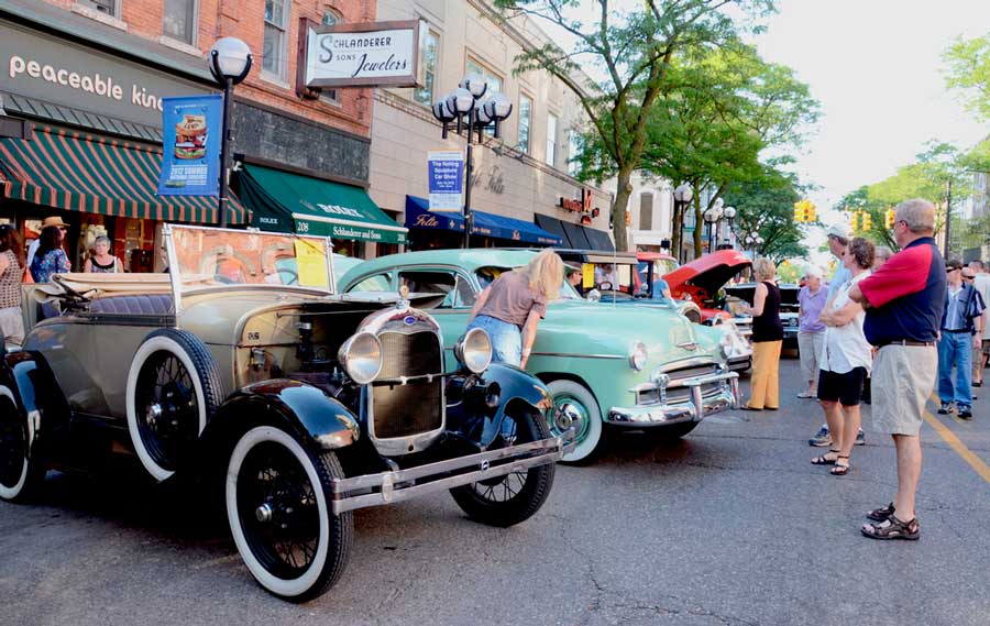 People looking at the cars displayed during the Classic Car Show in Ann Arbor