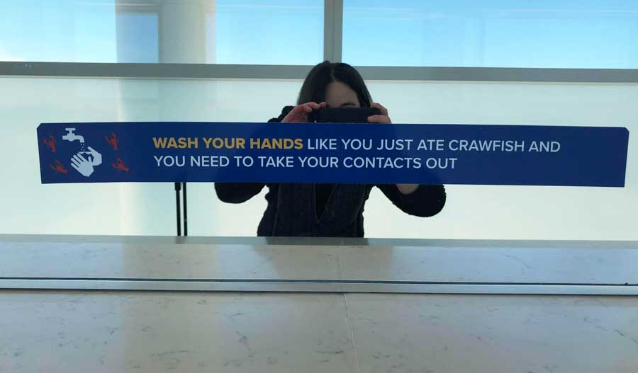 The author capturing a photo of a sign in Louis Armstrong International Airport