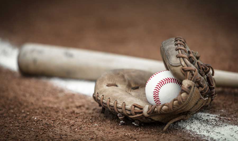 A baseball ball on a gloves and a baseball bat