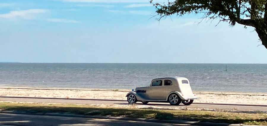 A car passing by the coast in Mississippi during a sunny morning