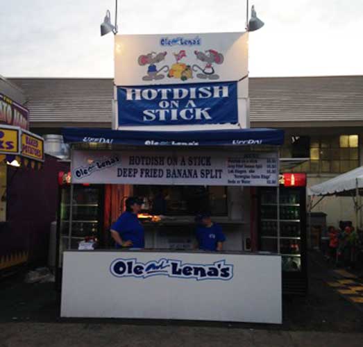 Two vendors on a food stand of Hotdish on a Stick