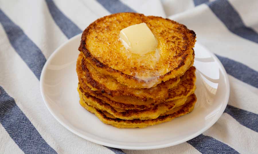 Johnnycakes on a plate topped with butter
