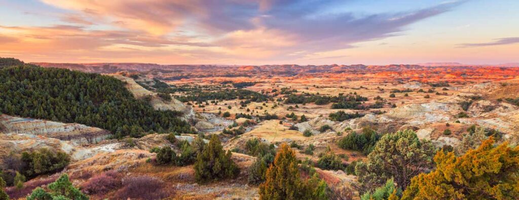 Colorful sky over the Theodore Roosevelt National Park during sunrise, one of the answers to the question What is North Dakota known for