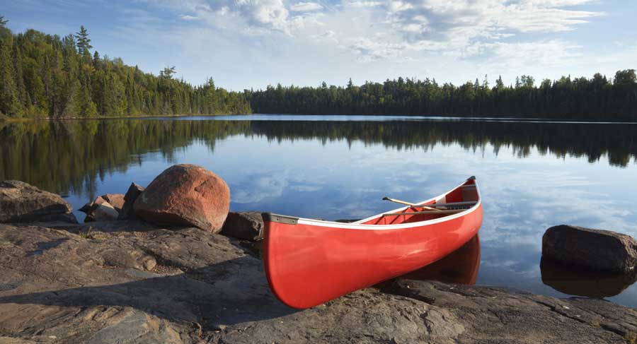 A red canoe on a rocky shore in Minnesota
