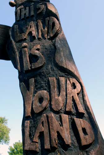 A tree with word carving outside Woody Guthrie's home